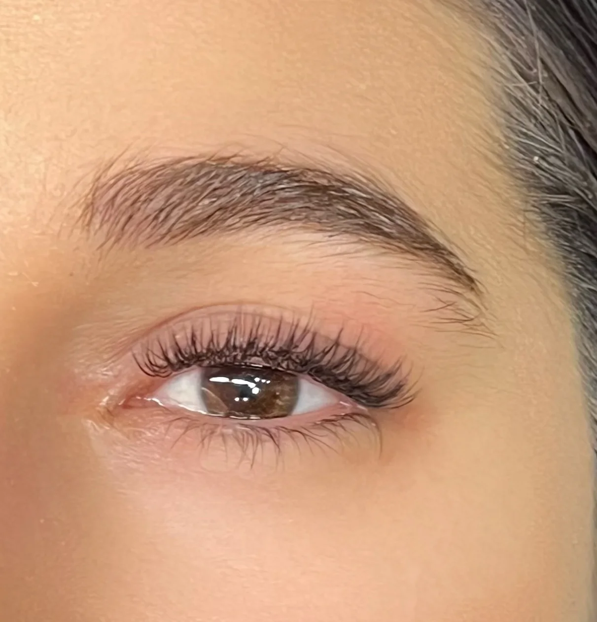 Close de um olho com extensão de cílios leve, de efeito natural